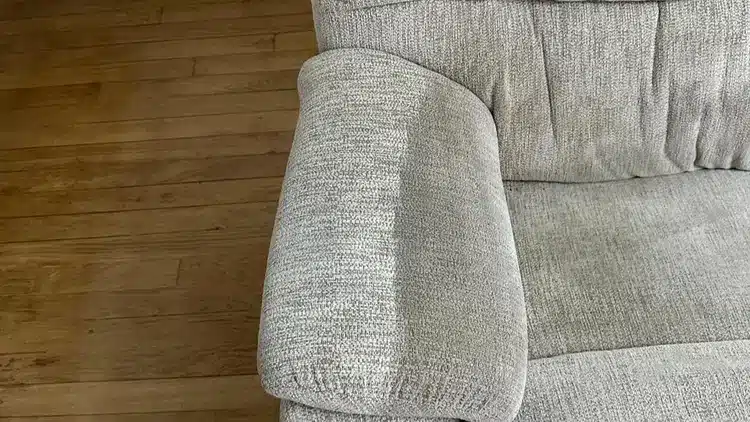 Grey sofa armrest on wooden floor.