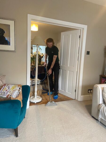 Person cleaning a room with vacuum.